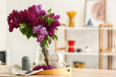 Mutfaktaki masada leylak çiçekli vazo.