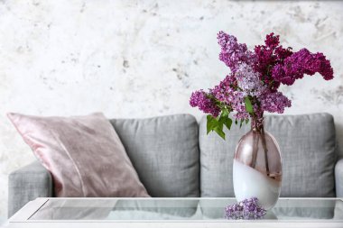 Masada leylak çiçekleri olan vazo.