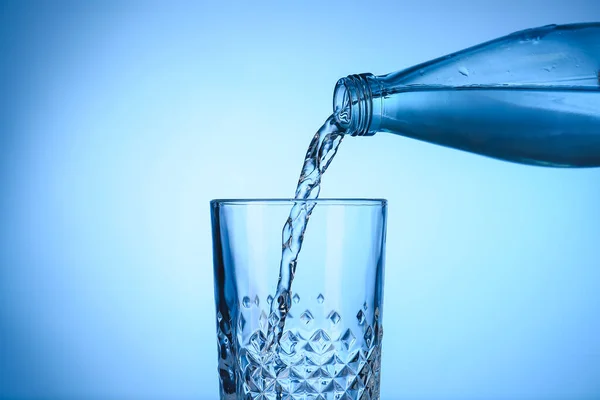 Giet Water Uit Fles Glas Kleur Achtergrond — Stockfoto