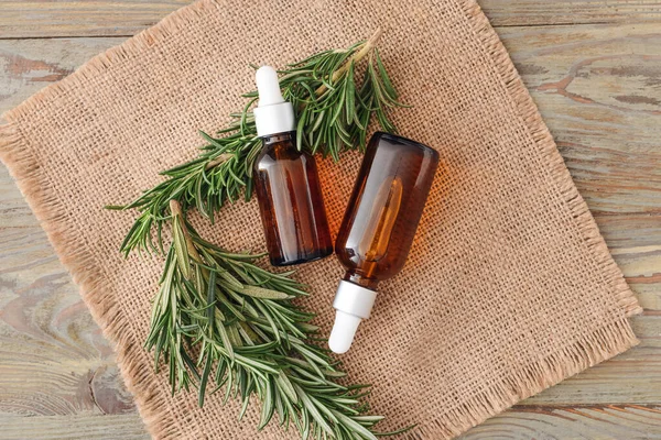 Bottles Essential Oil Fresh Rosemary Wooden Background — Stock Photo, Image