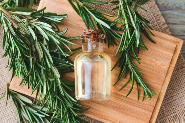 Flasche Ätherisches Und Frischer Rosmarin Auf Holzgrund Nahaufnahme — Stockfoto