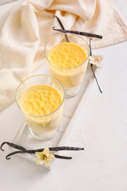 Açık arkaplanda lezzetli vanilyalı puding.