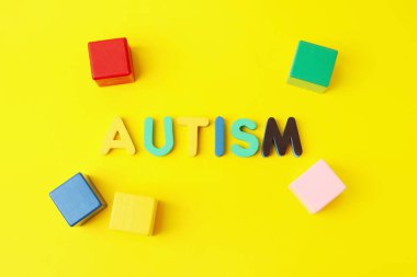 Renk arkaplanındaki sözcük AUTISM ve küpleri