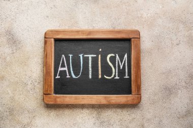 Grunge arka planında AUTISM sözcüğüyle tebeşir tahtası