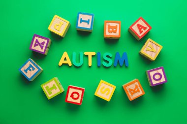 Renk arkaplanındaki sözcük AUTISM ve küpleri
