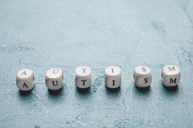 Grunge arkaplanındaki küplerden oluşan kelime AUTISM