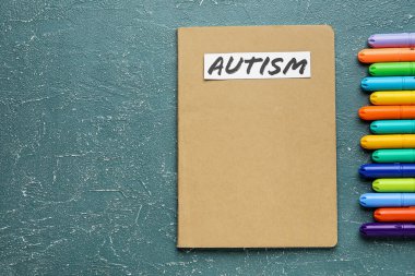 Kelime AUTISM ve grunge arkaplanda işaretleyiciler içeren defter