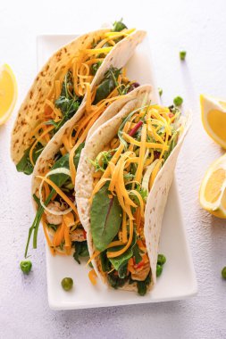 Hafif arka planda lezzetli taco ve limon tabağı.