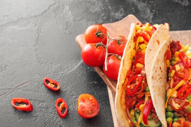 Koyu arkaplanda lezzetli tacolar olan tahta