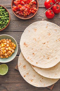Ahşap arka planda taco hazırlamak için gerekli malzemeler