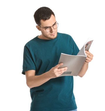 Genç adam beyaz arka planda dergi okuyor.