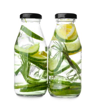 Beyaz arka planda salatalıklı limonata şişeleri