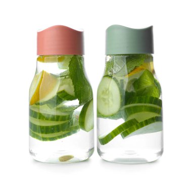 Beyaz arka planda salatalıklı limonata şişeleri