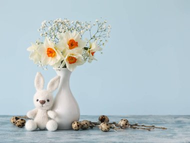 Güzel nergisli vazo, renkli bıldırcın yumurtası ve tavşan oyuncağı.