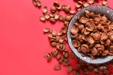 Renkli arka planda lezzetli mısır gevrekleri olan kase, yakın plan