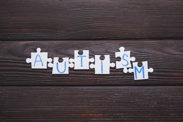 Word Autism Made Puzzles Dark Wooden Background — Stock Photo, Image