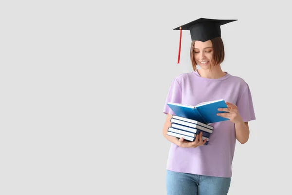 Estudiante Graduada Con Libros Sobre Fondo Claro — Foto de Stock