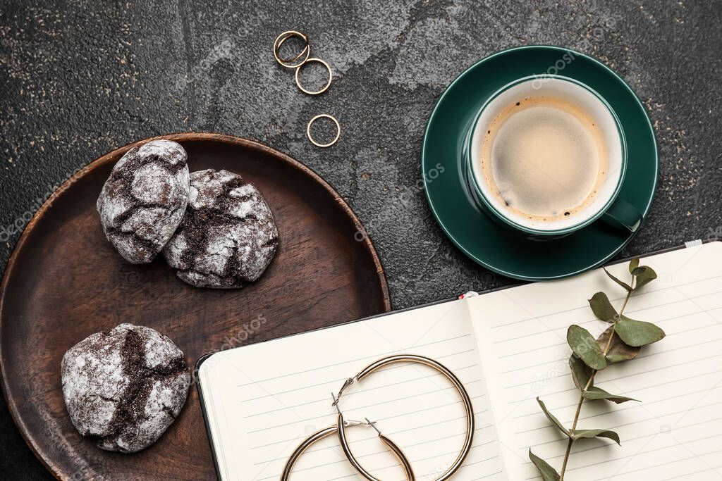 Cup of freshly brewed coffee and cookies on dark background