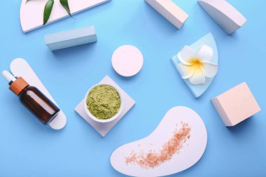 Kavanozda kuru kına tozu, gerekli yağ şişesi ve renk arkaplanında plumerya çiçeği karışımı.