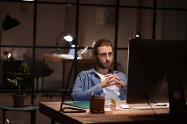 Geceleri ofiste çalışan yakışıklı adam.