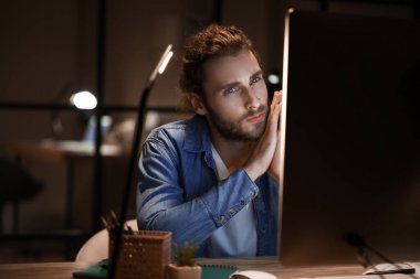 Geceleri ofiste çalışan yakışıklı adam.