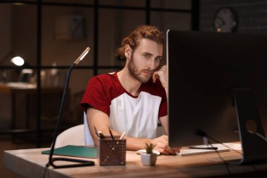 Geceleri ofiste çalışan yakışıklı adam.