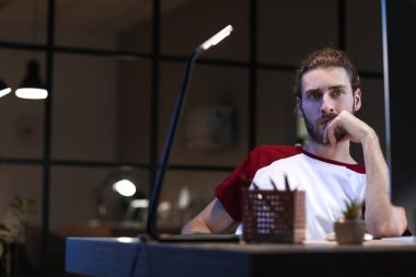 Geceleri ofiste çalışan yakışıklı adam.