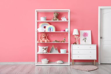 Renk duvarına yakın dekorlu ve çekmeceli raflar.