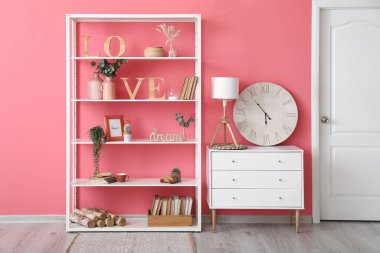 Renk duvarına yakın dekorlu ve çekmeceli raflar.