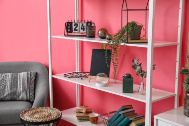 Renk duvarına yakın dekorlu kitap rafı