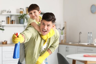 Baba ve oğul mutfağı temizlerken eğleniyorlar.