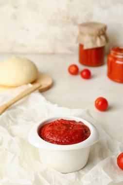 Hafif arka planda bir kase lezzetli sos ve hamur, yakın plan.