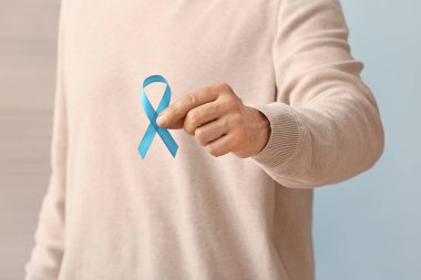 Renkli arka planda mavi kurdeleli adam, yakın plan. Prostat kanseri farkındalığı