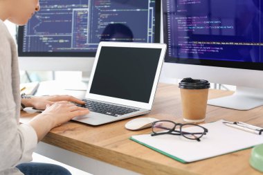 Ofiste dizüstü bilgisayarla çalışan kadın programcı