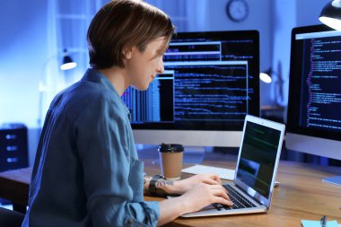Geceleri ofiste çalışan kadın programcı.
