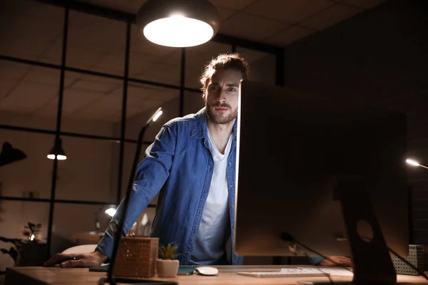 Handsome man working in office at night