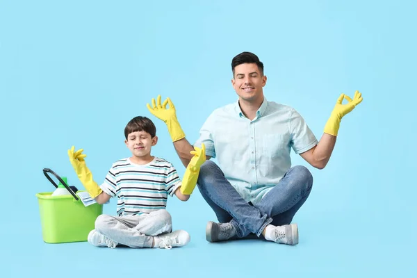 Father Son Cleaning Supplies Meditating Color Background — Stock Photo, Image