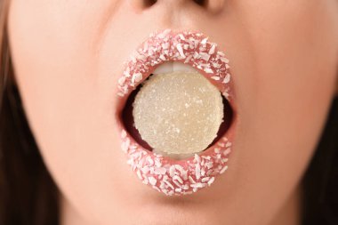 Yaratıcı makyajı ve tatlı şekeri olan güzel genç bir kadın. Yakın plan.