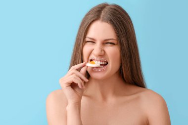 Yaratıcı makyajlı ve arkaplanda tatlı şekerler olan güzel genç bir kadın.