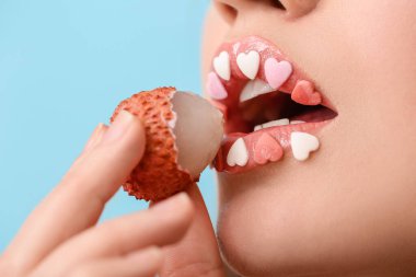 Yaratıcı makyajı ve litchi meyvesi olan güzel bir genç kadın. Yakın plan.