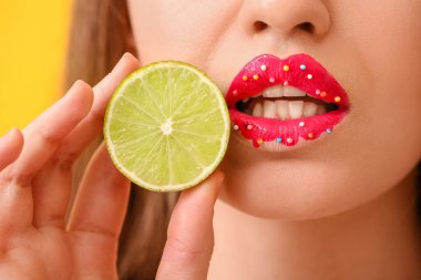 Yaratıcı makyajı ve limonu olan güzel genç bir kadın. Yakın plan.