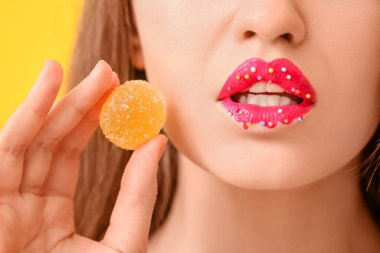 Yaratıcı makyajı ve tatlı şekeri olan güzel genç bir kadın. Yakın plan.