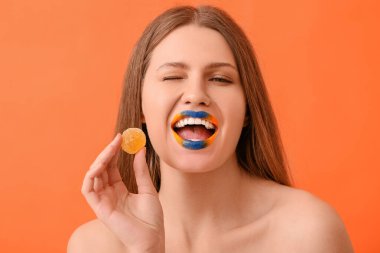 Yaratıcı makyajı ve renkli şekeri olan güzel bir genç kadın.