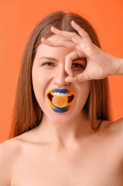 Yaratıcı makyajı ve şekeri olan genç ve güzel bir kadın renk arka planında iyi görünüyor.