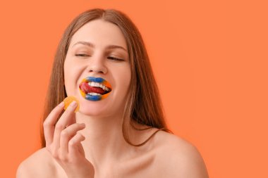 Yaratıcı makyajı ve renkli şekeri olan güzel bir genç kadın.