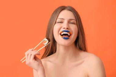 Yaratıcı makyajlı ve arkaplanda lezzetli suşi yuvarlanan güzel genç bir kadın.