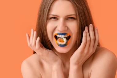 Yaratıcı makyajlı ve arkaplanda lezzetli suşi yuvarlanan güzel genç bir kadın.