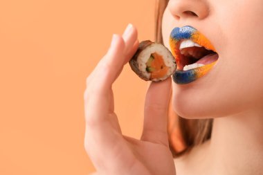 Yaratıcı makyajı ve lezzetli suşisi olan güzel bir kadın. Yakın plan.