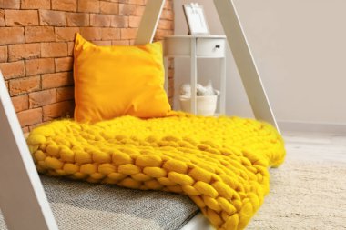 Modern çocuk yatağı ve ekose kumaşıyla iç mekan.