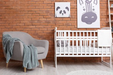 Rahat koltuğu ve bebek yatağı olan şık bir çocuk odası.